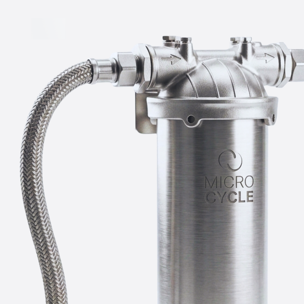 Front view of the assembled Microcycle cylindrical metal filter housing with two inline threaded connections.